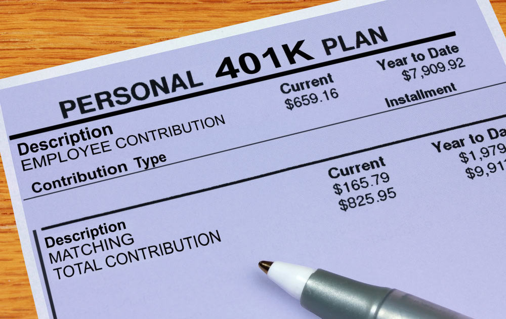 Close-up of a 401K plan document revealing contributions and totals, with a pen thoughtfully placed at the bottom, offering a snapshot of prudent retirement planning.