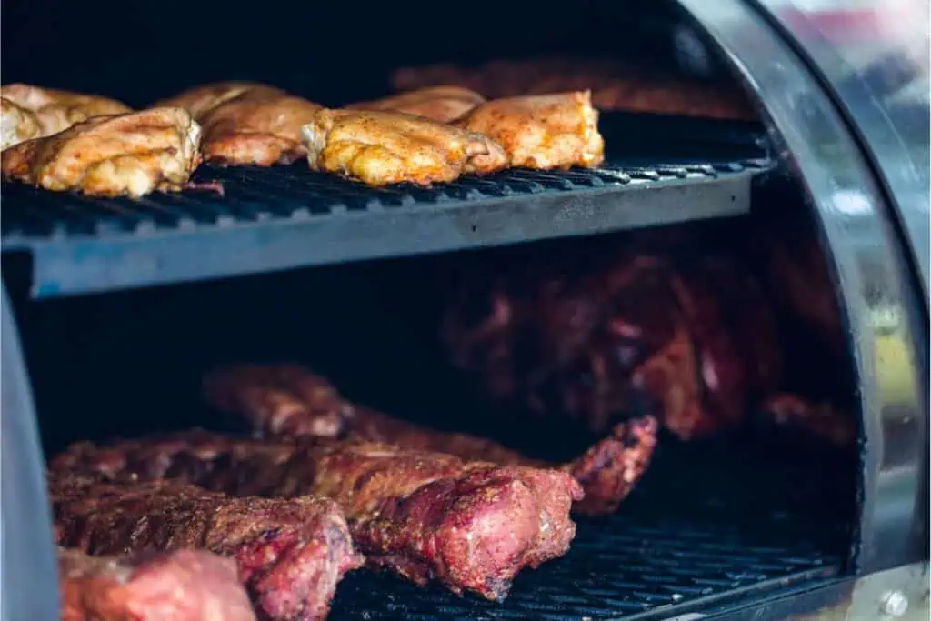 Chunks of meat slowly sizzle inside the smoker, with chicken gracing the top rack and ribs below. This age-old technique not only infuses flavor but also offers a way to preserve meat without a refrigerator, capturing the essence of traditional storage methods.