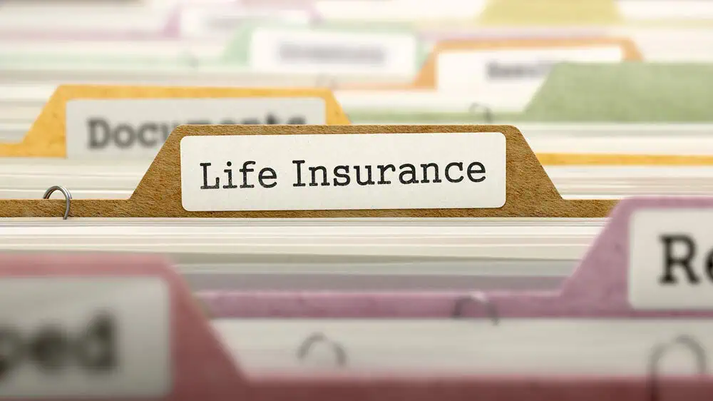 A labeled file folder reading "Life Insurance" is neatly organized among other folders, illustrating the importance of knowing how to buy life insurance and keep your documents in order.