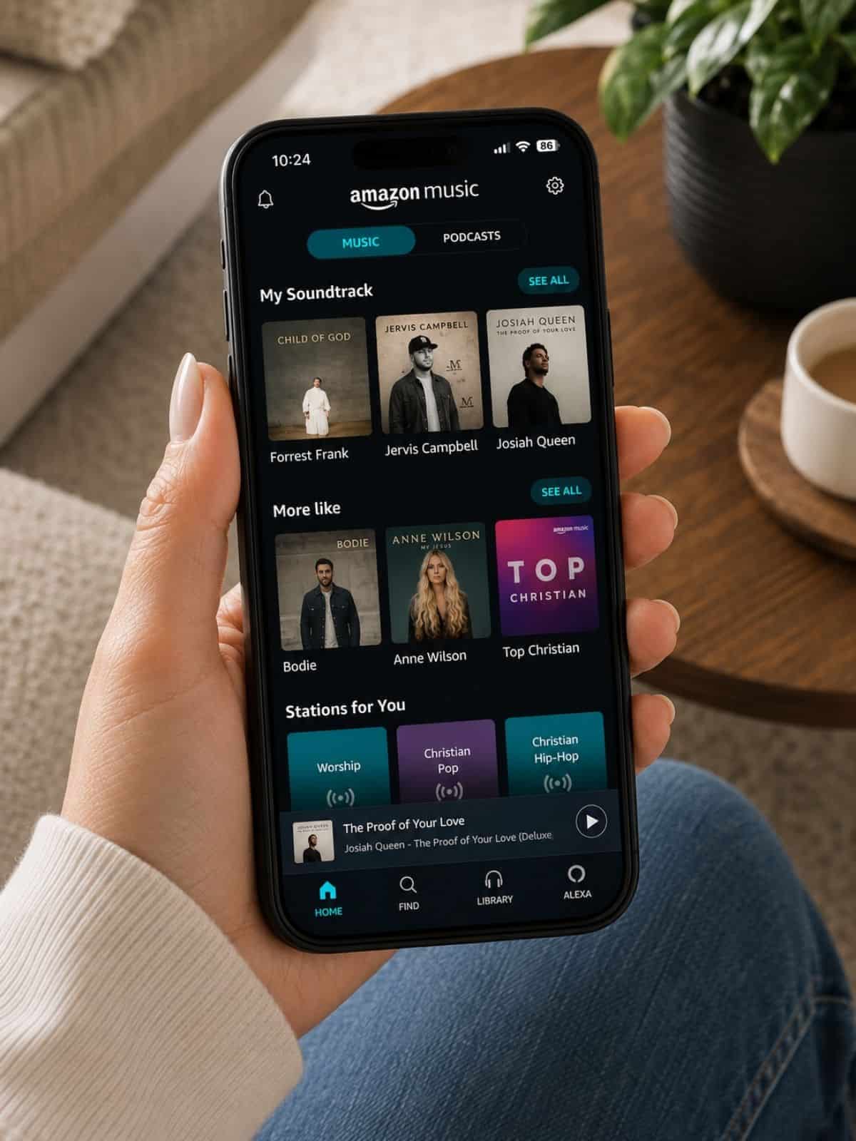 A hand holds a smartphone displaying the Amazon Music app, featuring playlists and album covers under the Music and Podcasts tabs, highlighting access with Amazon Music Unlimited.