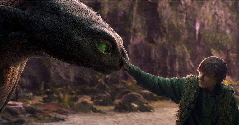 A young person gently touches the nose of a large dragon in a forest setting, with soft light illuminating both figures, evoking the magic of How to Train Your Dragon.