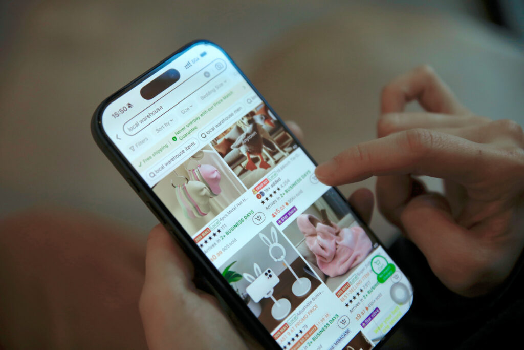A person uses a smartphone to browse online listings for decorative items, including animal-shaped and bunny-themed products, on the Temu shopping app.